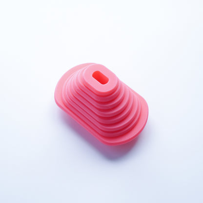 Dog tag-shaped polymer clay cutters 3D printed in pink PLA filament nested in descending sizes.